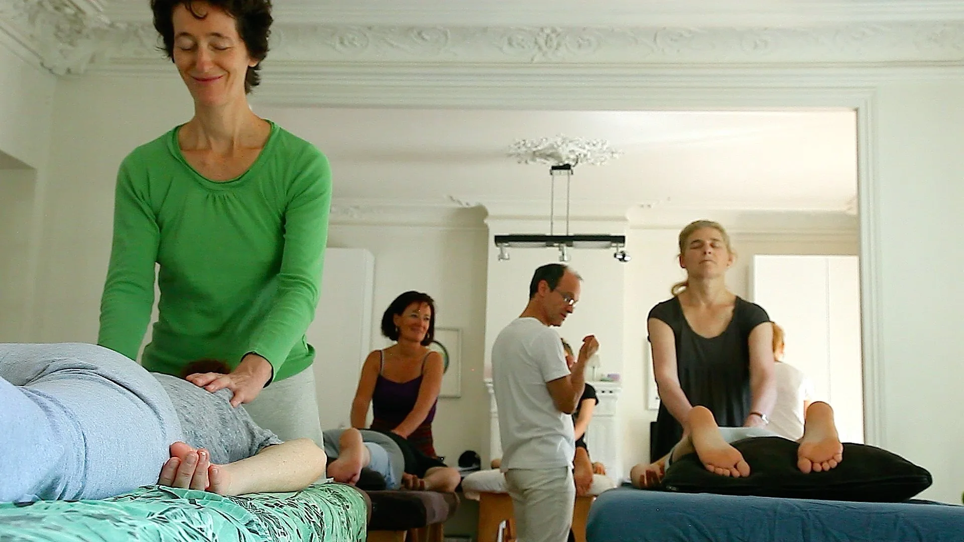 Stagiaires en pratique autour de plusieurs tables pendant un week-end de formation